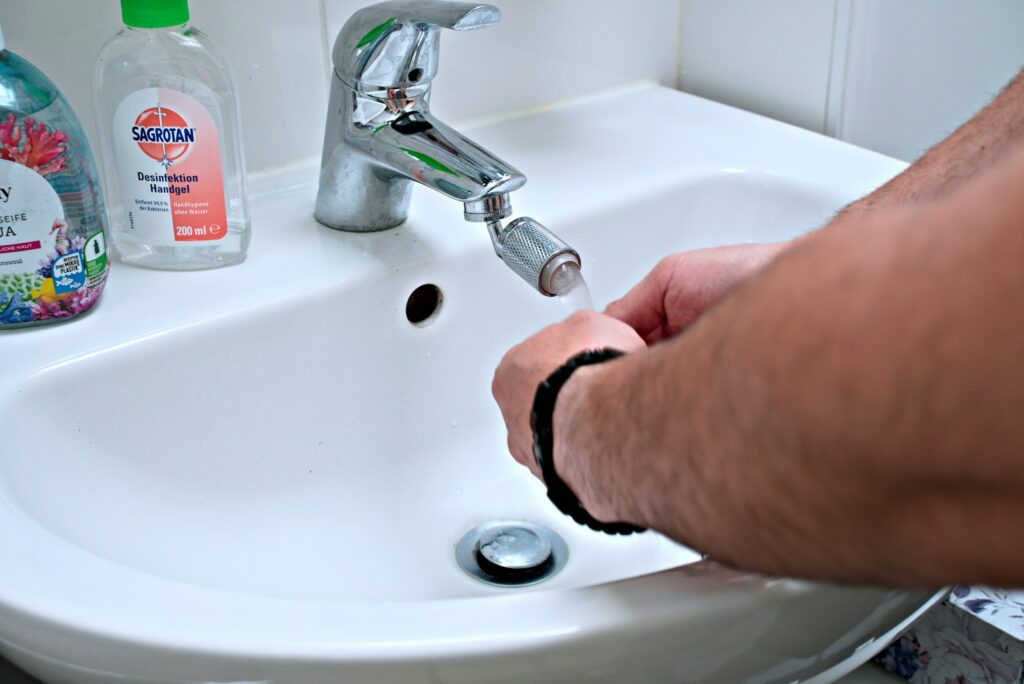a person is washing their hands in a sink